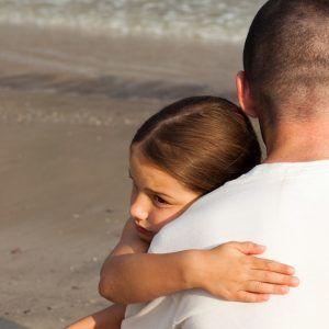 Padre abrazando a su hija en una playa - Estrategias de marketing creativo y confiable para tu negocio que realmente funcionan - Imagen